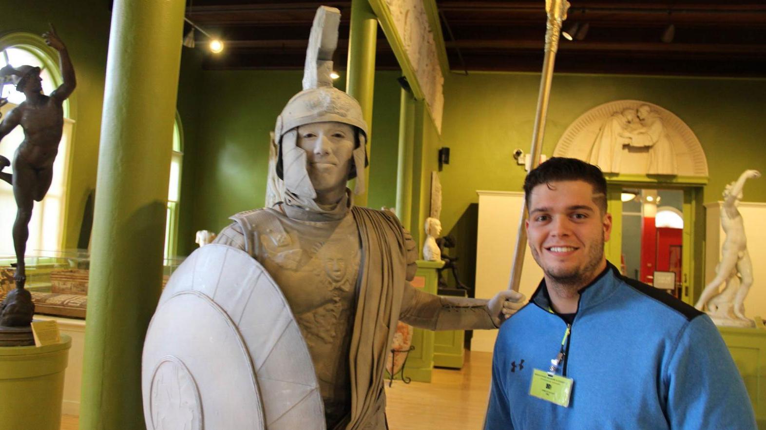 Hogan Tomkunas poses with a statue at his internship.