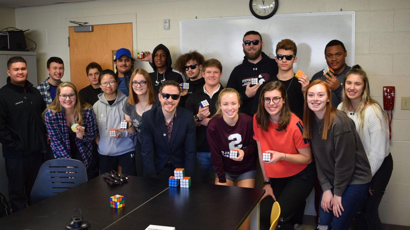 A group of students from the Springfield College Department of Mathematics, Physics, and Computer Science stand together at a Rubik's Cube competition